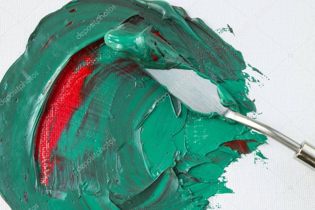Mixing green and red paint on a white canvas