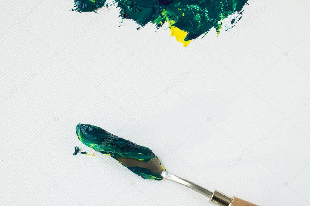 Mixing yellow and green paint on a white canvas