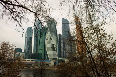 Moskova / Rusya-Aralık, 8, 2019: Bulutlu bir sonbahar gününde binaların cam duvarlarına yansıyan modern Moskova mimari kompleksi ve nehir seti manzarası