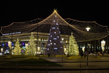 Moskova / Rusya - 20 Aralık 2019: Aydınlatma ve çelenklerle dolu Noel ağacı Lubyanka Meydanı 'ndaki kara gökyüzüne karşı