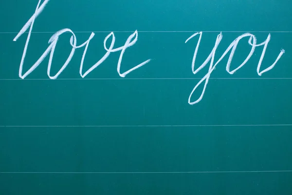 Chalked I love you in English nope on a green school Board