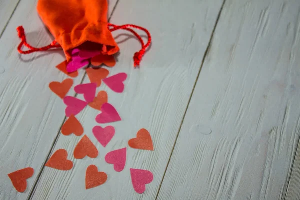 Una Bolsa Roja Con Corazones Derramados Sobre Una Superficie Madera —  Fotos de Stock