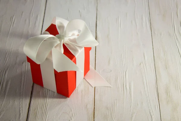 Roter Quadratischer Geschenkkarton Mit Satinschleife Auf Weißem Tisch — Stockfoto