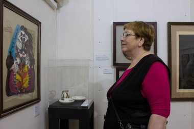 Moskova-Rusya-3 Ocak 2020: Bir sanat müzesinin içindeki resimlere bakan yaşlı kadın