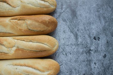 Gri arkaplanda taze pişmiş baget ve kopyalamak için yer var.