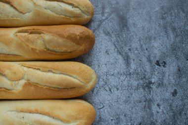 Gri arkaplanda taze pişmiş baget ve kopyalamak için yer var.