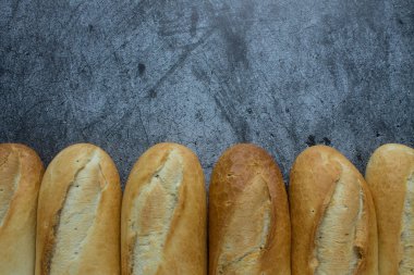 Gri arkaplanda taze pişmiş baget ve kopyalamak için yer var.