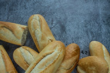 Gri arkaplanda taze pişmiş baget ve kopyalamak için yer var.