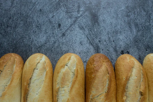 Fresh baked baguettes on a grey background with space for copying