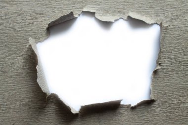 Üzerinde yırtık bir delik olan eski gri bir kağıttan yapılmış çerçeve ve beyaz bir arka plan