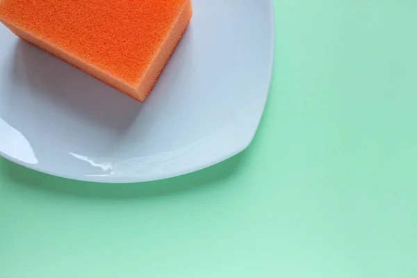 Оранжевая Губка Мытья Посуды Квадратной Белой Тарелке Крупным Планом Ровном — стоковое фото