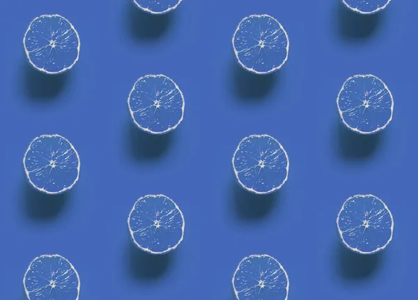 Monochrome pattern: lemon slices with shadow on a classic blue background