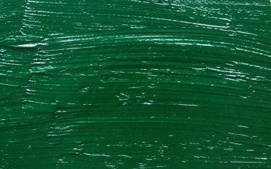 Texture background: monochrome green large strokes of oil paint on canvas in close-up with copy space