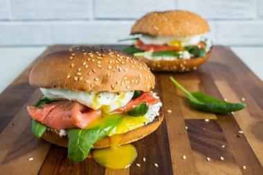 Ispanaklı burger, balık ve yumurtalı benedict, badem ezmeli taze rulo, yakın plan tuğla duvara karşı fotokopi alanı ile.