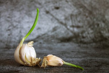 Sarımsak başlıklı yeşil lahanalı ve kabuklu, desenli gri arka planda kopyalamak için alan var.