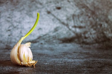 Sarımsak başlıklı yeşil lahanalı ve kabuklu, desenli gri arka planda kopyalamak için alan var.