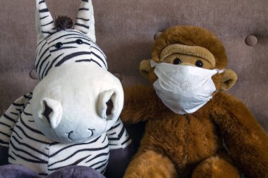 Plush stuffed toys: a Zebra and a monkey in a homemade medical mask made of a wet sanitary napkin. Concept: medicine and healthcare, protection from coronavirus.