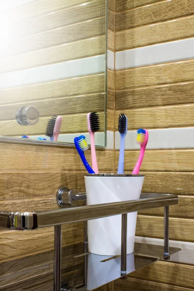 Four Toothbrushes White Plastic Cup Metal Shelf Close Wall Concept — стокове фото