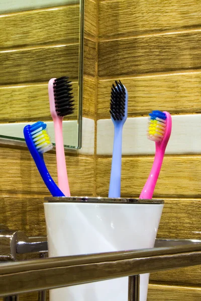 Four Toothbrushes White Plastic Cup Metal Shelf Close Wall Concept — Stock Photo, Image