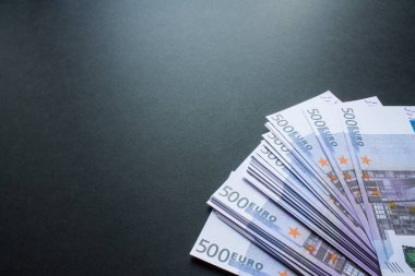 500 Euro 'luk banknotlar, fotokopi alanı olan siyah bir arkaplana yakından çekilmiş.