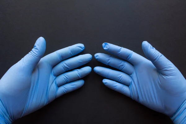 Zwei Hände Blauen Gummihandschuhen Auf Schwarzem Hintergrund Nahaufnahme Mit Raum — Stockfoto