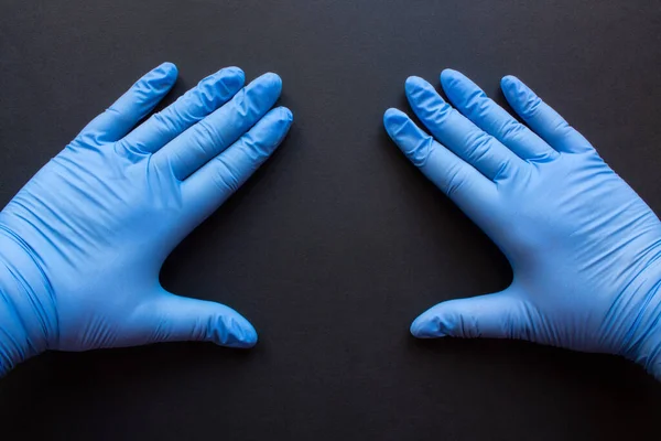 Zwei Hände Blauen Gummihandschuhen Auf Schwarzem Hintergrund Nahaufnahme Mit Raum — Stockfoto