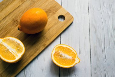 Taze, parlak limonlar. Mutfak tahtasının üzerinde bir meyve ve iki yarısı. Yakın plan.