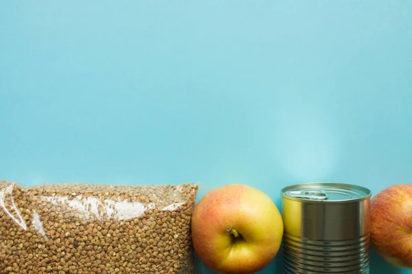 Lebensmittelspenden Buchweizen Konserven Und Äpfel Auf Blauem Hintergrund Mit Kopierplatz — Stockfoto