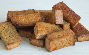 Kızarmış ekmeğin dikdörtgen parçaları beyaz bir arka planda yakın plan.