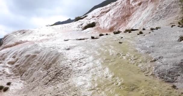 Минеральная вода течет по травертиновым террасам из источника в горах — стоковое видео