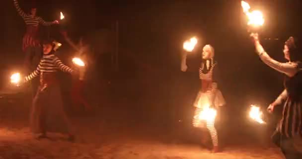 Пожежні артисти Виконання циркового шоу на пляжі після заходу сонця. — стокове відео