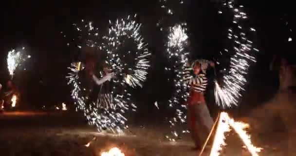 Vuurshow artiesten voeren een circus show op het strand na zonsondergang. — Stockvideo