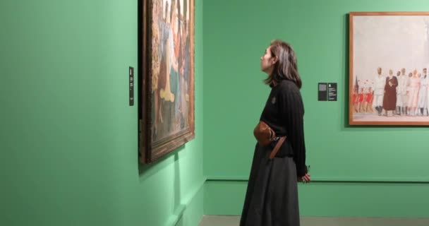 Giovane woomen guardando la pittura nella galleria d'arte con pareti verdi — Video Stock