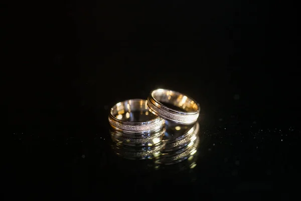 Pair of Wedding Rings On The Countertop Of The Black Table