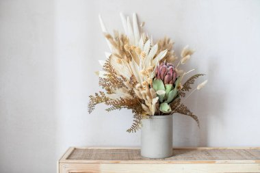 Ev dekorasyonu olarak kurumuş çiçeklerin silindirik seramik vazoda minimalist bileşimi. 