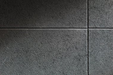 Üzerine gri bir ses emici panel monte edilmiş bir duvarın dokusunu kapat. Ses geçirmez duvar, ses stüdyosunda, müzik salonunda ya da kulüpte sıkıştırılmış liflerden yapılmış..