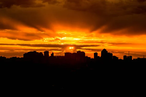 Sol nascendo sobre a cidade durante o pôr do sol quente com nuvens — Fotografia de Stock