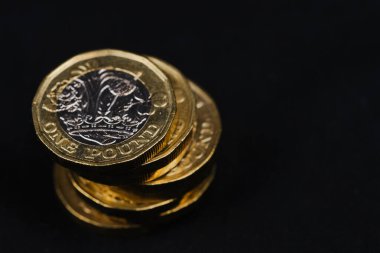 kopyalama alanı olan siyah arkaplana karşı bir pound İngiliz sikkesi kullanılmış