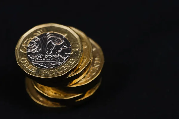 kopyalama alanı olan siyah arkaplana karşı bir pound İngiliz sikkesi kullanılmış