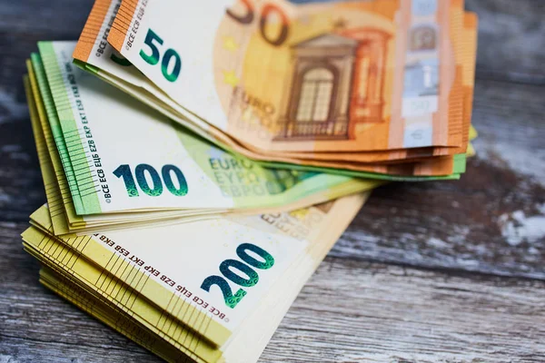 Ahşap yüzeyde 50, 200 Euro 'luk banknot yığını.