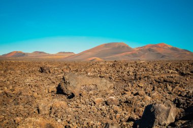 Lanzarote 'deki Timanfaya Ulusal Parkı' ndaki volkanik kayalarla kaplı manzara