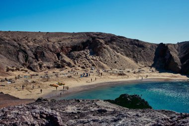 İspanya 'nın Lanzarote kentindeki Playa de Papagayo plajındaki insanlar