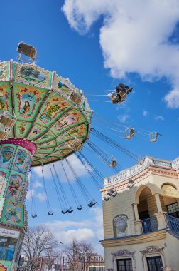 Avusturya, Viyana 'da güneşli ve bulutlu bir günde ünlü Prater' da salıncak gezintisi