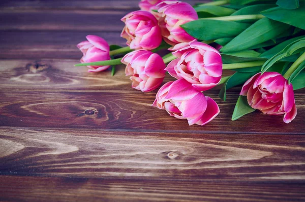 Rosa tulpaner ligger på brun trä bakgrund med kopia utrymme — Stockfoto