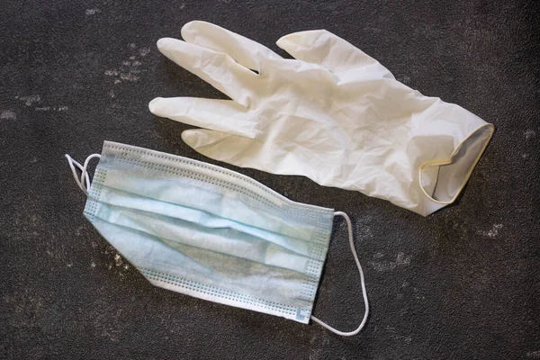 Siyah arka planda tıbbi maske ve lastik eldivenler. Virüs ve Grip Kontrolü