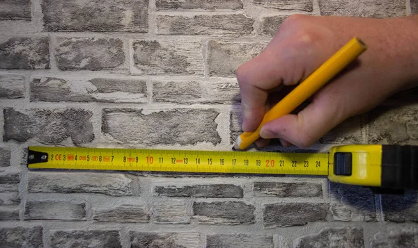 Measured with a tape measure and mark with a pencil on a brick wal