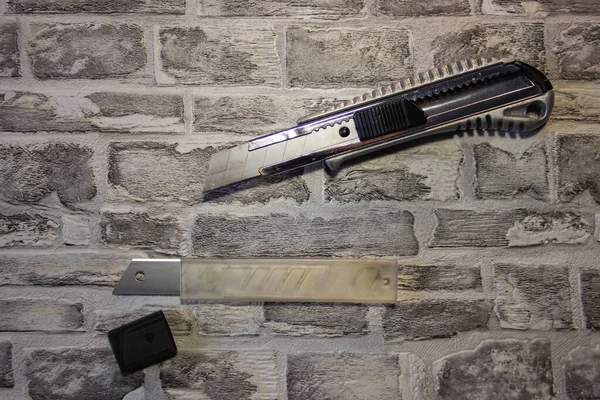 Αποσυναρμολογημένο Μαχαίρι Χαρτικών Αντικατάσταση Λεπίδας Μαχαίρι Ένα Τούβλο Τοίχο Backgroun — Φωτογραφία Αρχείου