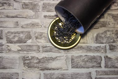 Siyah Çiviler bir tuğlaya karşı metal ayakta duruyor.