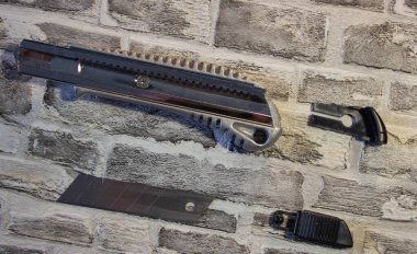 Parçalanmış kırtasiye bıçağı, duvarın arkasında bıçakla değiştirilmiş bıçak.