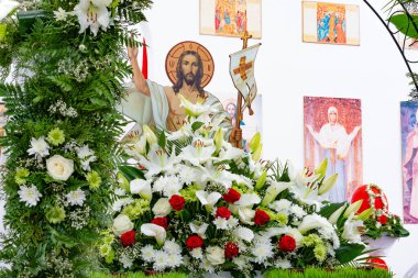 Orlovshchina, Ukrayna, Ortodoks Kilisesi, 04.28.2019. Büyük Paskalya kutlaması. Gonfalonlu Hz. İsa 'nın görüntüsü farklı çiçek buketleri ve kemer ile süslenmiş bir mezarın üzerinde duruyor..